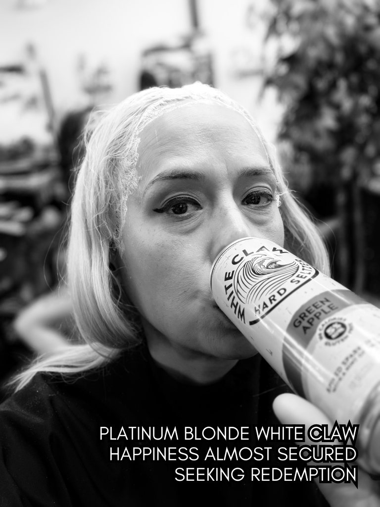 Black-and-white selfie of Baroque Medusa drinking from a can during a hair appointment, paired with a haiku about desire, indulgence, and redemption.