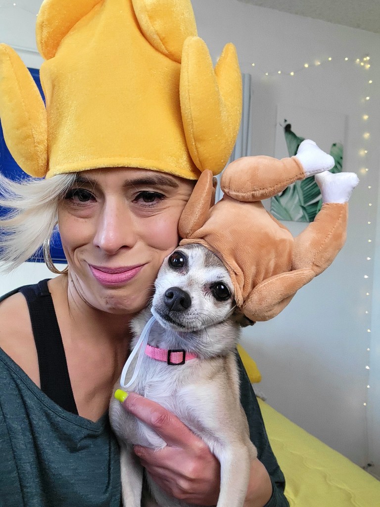 Baroque Medusa holding Fenway while wearing matching turkey hats in a playful Thanksgiving-themed portrait.