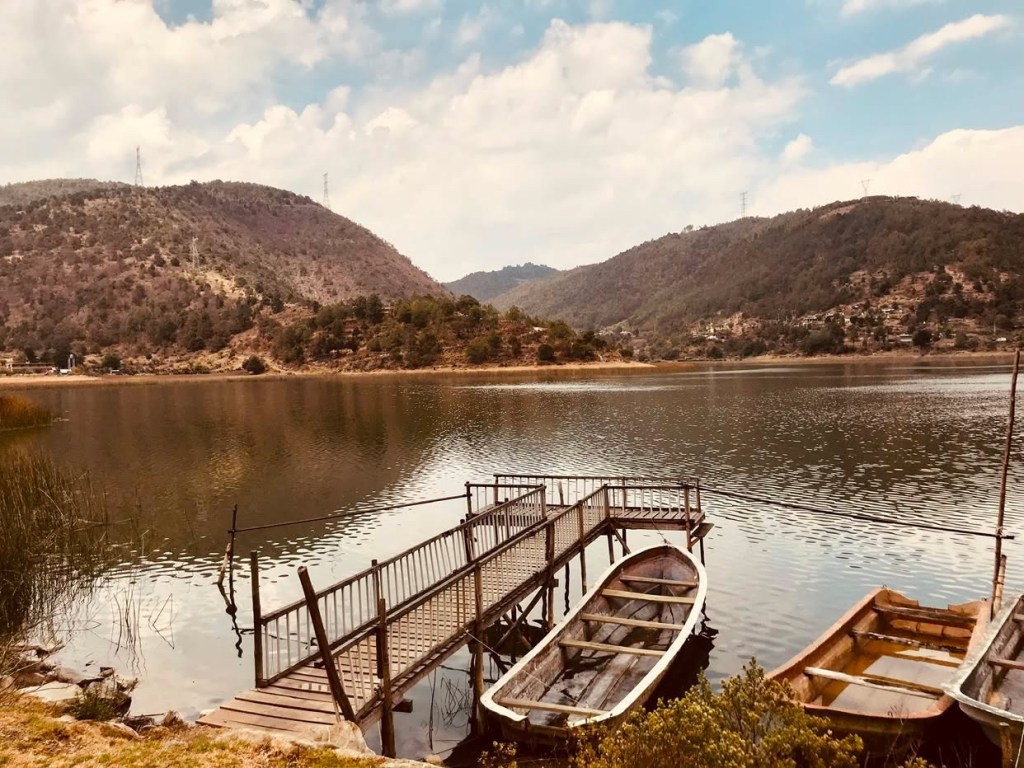 Mountain lake with a wooden dock and rowboats in Mexico, submitted through Baroque Medusa’s Instagram camera roll call and used in It’s a Small Dystopian World.